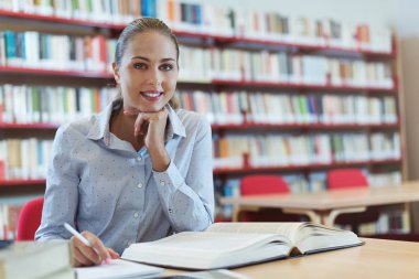 Kütüphanede gülümseyen öğrenci