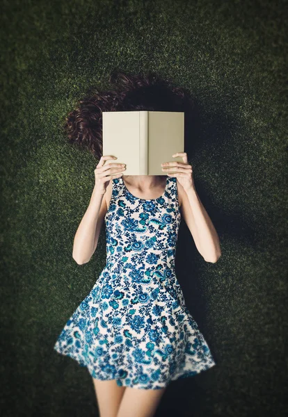 Jeune femme couchée au parc sur l'herbe — Photo