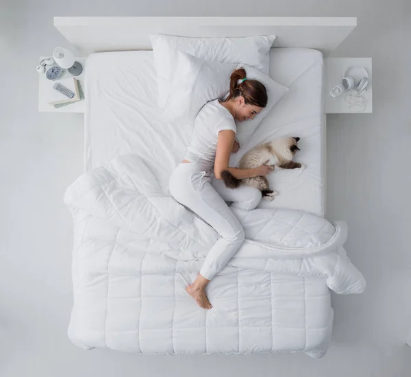 Mujer y su gato en el dormitorio — Foto de Stock