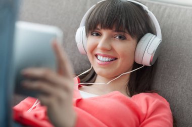 Kadın kulaklıklarla tablet kullanma