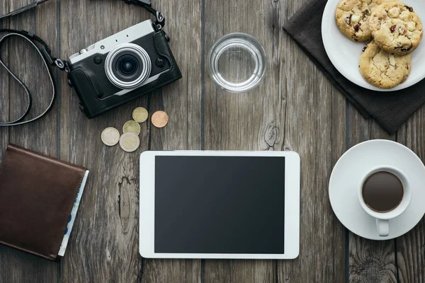 Câmera vintage, tablet, uma xícara de café e biscoitos em um desktop de madeira — Fotografia de Stock