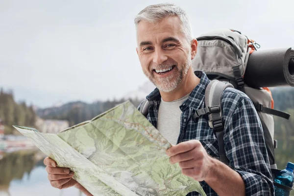 Caminhante procurando direções em um mapa — Fotografia de Stock