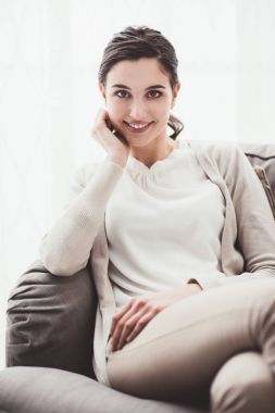 Gülümseyen kız kanepede