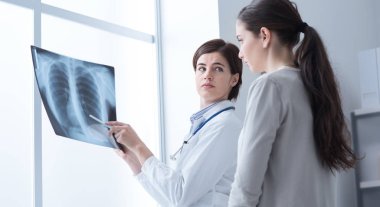Doctor examining patient's x-ray clipart