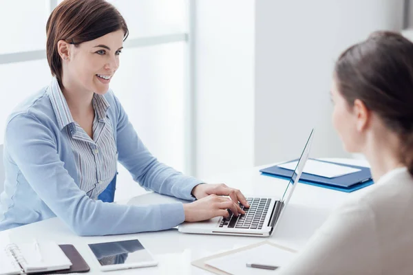 Zakelijke bijeenkomst in het kantoor, een vrouwelijke manager typt op een laptop en glimlachen — Stockfoto