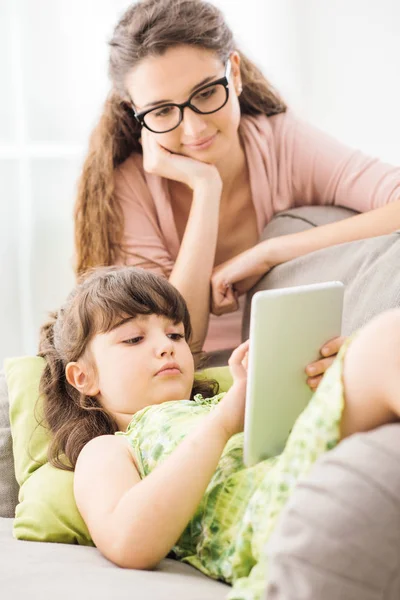 Mutter und Tochter benutzen gemeinsam ein Tablet — Stockfoto