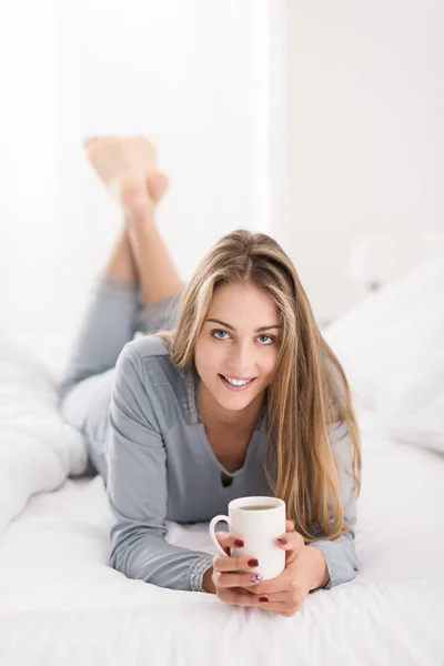 Приваблива молода жінка сидить у ліжку і позує — стокове фото