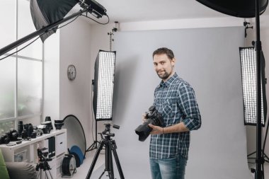 Profesyonel fotoğrafçı stüdyoda poz veriyor.