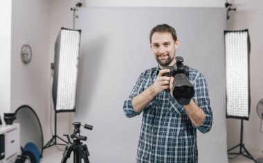 Profesyonel fotoğrafçı stüdyoda poz veriyor.