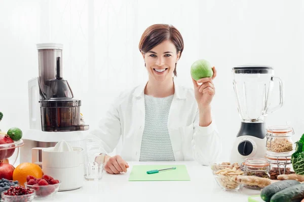 Nutricionista sonriente sosteniendo una manzana —  Fotos de Stock