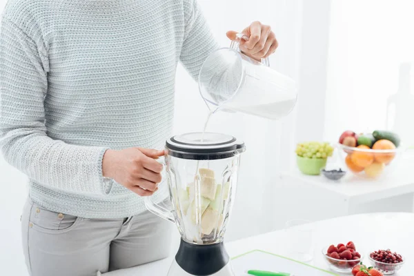 Mulher preparando smoothie com leite — Fotografia de Stock