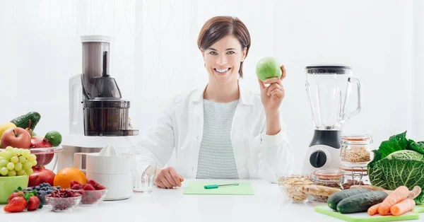 Leende nutritionist holding ett äpple — Stockfoto