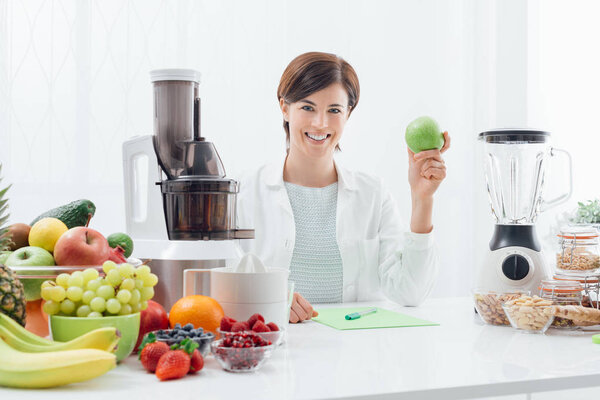 Smiling nutritionist holding an apple