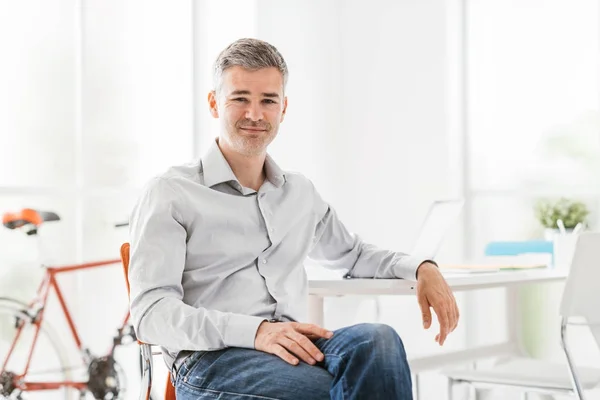 Confident businessman sitting in his office — Stock Photo, Image