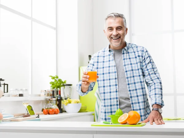 Man having a glass of fresh orange juice — Stock Photo, Image