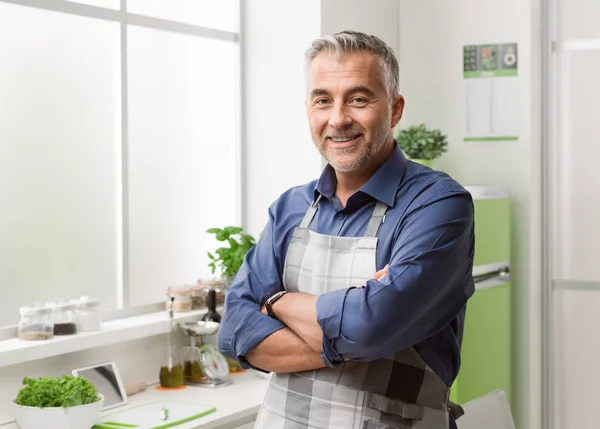 Homem sorridente confiante posando em sua cozinha — Fotografia de Stock