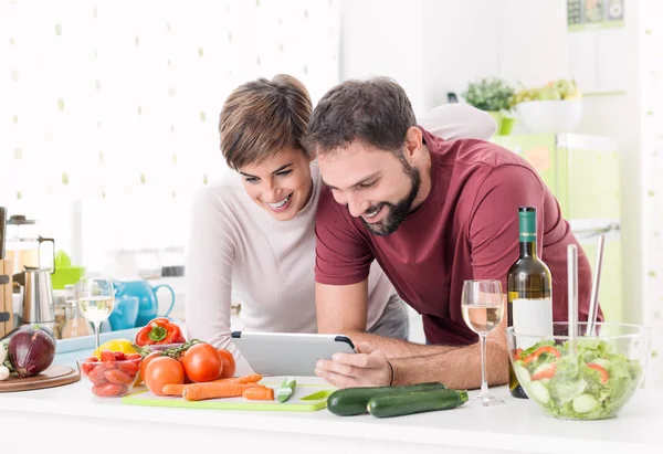 Çift birlikte yemek ve tablet kullanma — Stok fotoğraf