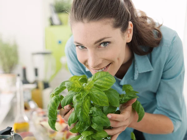 Vrouw ruiken verse basilicum thuis — Stockfoto