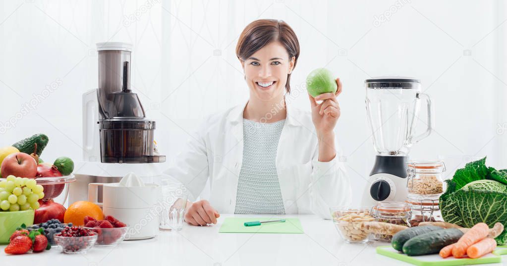 Smiling nutritionist holding an apple