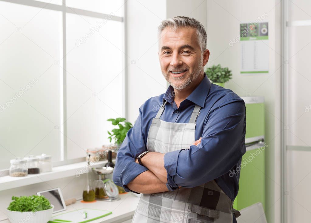 Confident smiling man posing in his kitchen