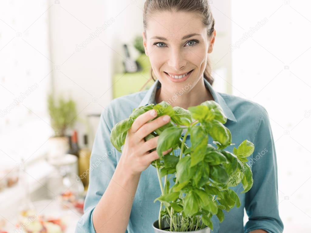 Woman holding a plant of fresh basil