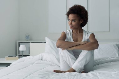 Yatakta oturan kadın.