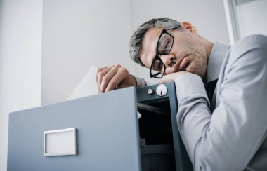 Tired office worker sleeping in the office clipart