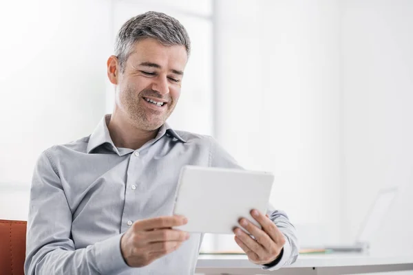 Empresário usando um tablet no escritório — Fotografia de Stock