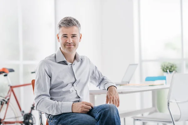 Selbstbewusster Geschäftsmann sitzt in seinem Büro — Stockfoto