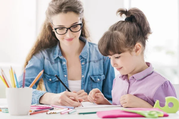 Joven madre y niña dibujando juntas — Foto de Stock