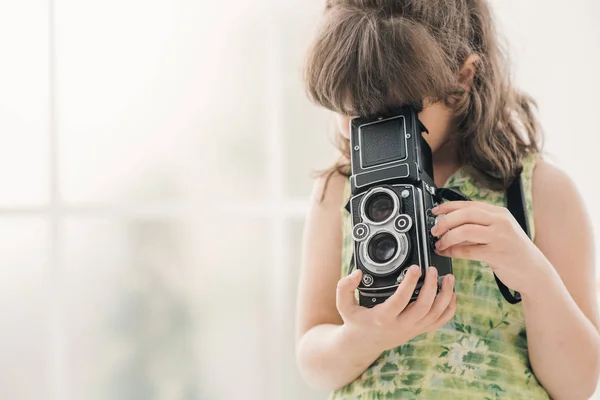 Young girl holding a vintage camera — Stock Photo, Image