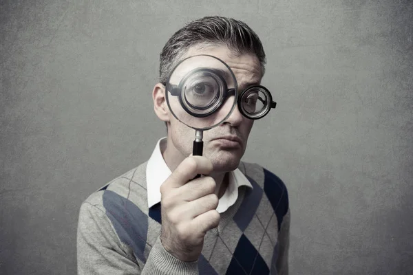 Guy looking through a magnifying glass — Stock Photo, Image