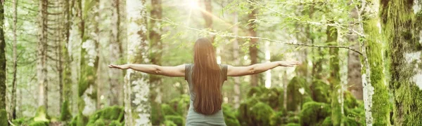 Woman spreading arms in the forest — Stock Photo, Image