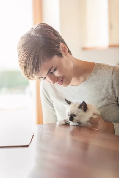 Onu yavru kedi tutan kadın — Stok fotoğraf