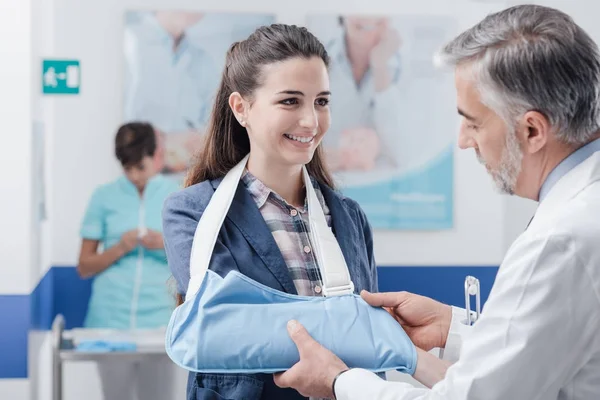 Médico visitando a un paciente con el brazo roto — Foto de Stock