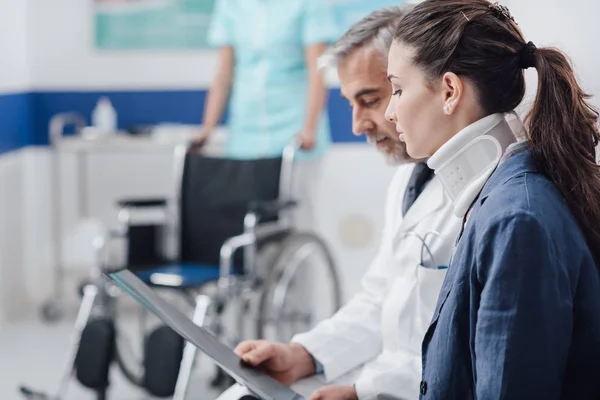 Medico in visita a un paziente con collare cervicale — Foto Stock