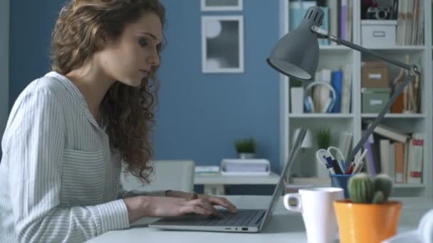 Jonge vrouw met haar laptop werkt en hoofdpijn hebben — Stockvideo