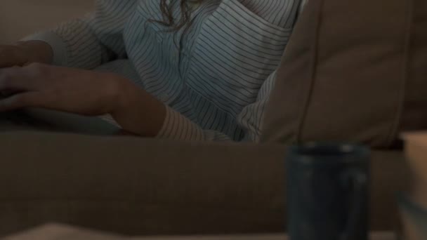 Молодая женщина отдыхает на диване и болтает — стоковое видео