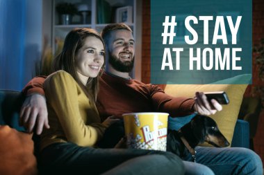 Karantinaları sırasında geceleri birlikte film izleyen rahat bir çift: Coronavirus önleme için sosyal medya kampanyasında evde kalın
