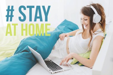 Mutlu kadın yatakta uzanıp internetten film izliyor: Coronavirus önleme için sosyal medya kampanyasında evde kalın