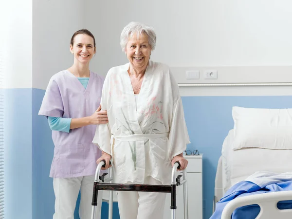 Hastanede Kıdemli Bir Hastaya Yardım Eden Gülümseyen Profesyonel Hemşire Kadın — Stok fotoğraf
