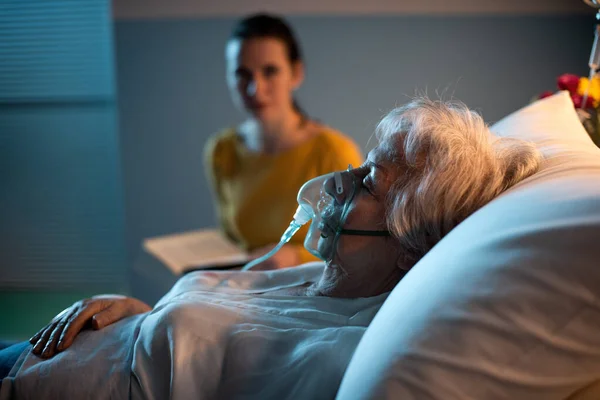 Жінка Лікарні Допомагає Пацієнту Кисневою Маскою Вночі Вона Читає Книгу — стокове фото