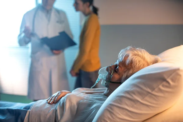 Senior Patient Sjukhuset Ligger Sängen Och Läkare Talar Med Familjemedlem — Stockfoto