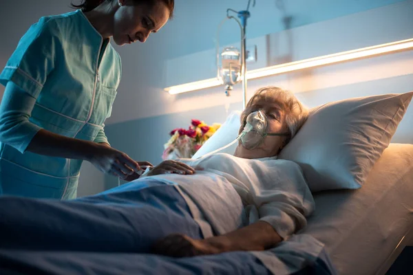 Profesionální Zdravotní Sestra Kontroluje Starší Ženu Ležící Posteli Nemocnici — Stock fotografie