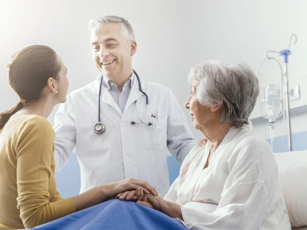 Médico Sonriente Profesional Reuniéndose Con Una Paciente Mayor Hija Hospital —  Fotos de Stock