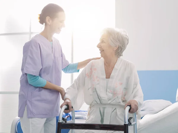 Усміхнена Професійна Медсестра Яка Допомагає Старшому Пацієнту Лікарні Жінка Спирається — стокове фото