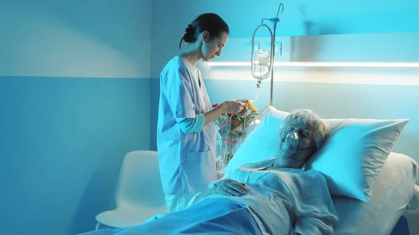 Szakmai Nővér Ellenőrzi Egy Idősebb Feküdt Ágyban Kórházban — Stock Fotó
