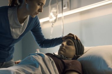 Genç bir kadın terapi sırasında arkadaşına yardım ediyor. Alnına dokunup onu kontrol ediyor.