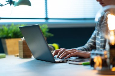 Profesyonel iş kadını masa başında oturuyor ve laptopuyla evden çalışıyor.
