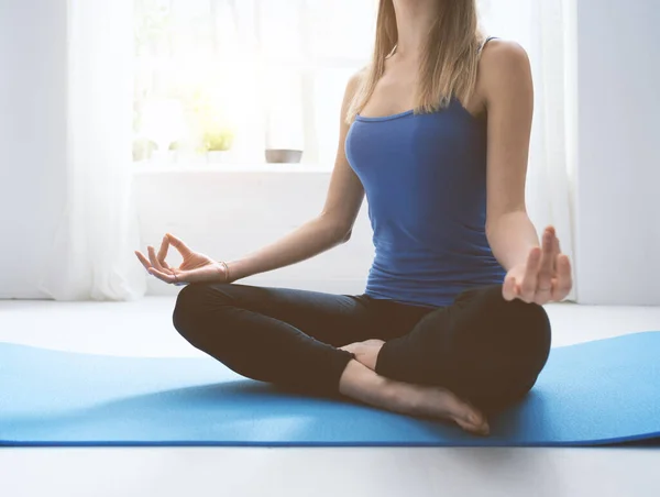 自信を持って女性練習マインドフルネス瞑想家で 彼女は組んだ足マットの上に座っています — ストック写真
